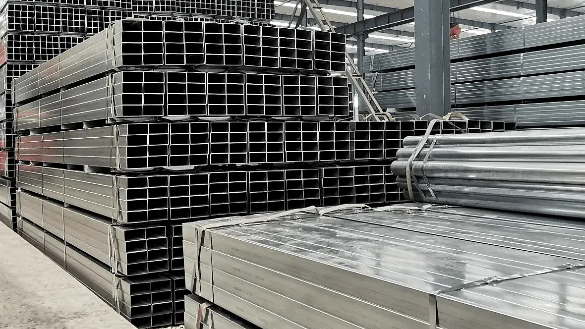 Atados de tubería rectangular galvanizada apilados en una bodega industrial